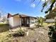 Exterior view of home featuring enclosed sunroom with large windows and a landscaped yard at 716 Caribou Dr, Kissimmee, FL 34759