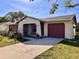 Ranch-style home with an attached garage, and landscaping at 716 Caribou Dr, Kissimmee, FL 34759