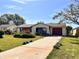 A single-story home featuring a driveway, garage and manicured lawn at 716 Caribou Dr, Kissimmee, FL 34759