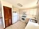 Bright kitchen featuring white appliances, cabinetry, and tile flooring at 716 Caribou Dr, Kissimmee, FL 34759