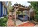 Backyard featuring a pergola with bench swing, brick patio, and landscaping at 719 S Summerlin Ave, Orlando, FL 32801