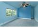 Bright bedroom featuring a ceiling fan, plush carpeting, and a large window at 719 S Summerlin Ave, Orlando, FL 32801