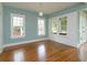 Light-filled living room with hardwood floors, large windows, and blue accent wall at 719 S Summerlin Ave, Orlando, FL 32801