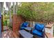 Outdoor patio with wicker furniture featuring blue cushions, wood fence, and lush landscape at 719 S Summerlin Ave, Orlando, FL 32801