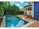 Backyard with a pool, basketball hoop, landscaping and house with blue siding at 719 S Summerlin Ave, Orlando, FL 32801