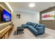 Cozy living room featuring a blue sectional sofa, flat screen TV, and Orlando skyline wall art at 7940 Formosa Valley Pl, Kissimmee, FL 34747