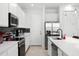 Modern kitchen with stainless steel appliances, white cabinets, and a kitchen island at 824 Longboat Dr, Davenport, FL 33896