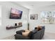 Cozy living room featuring a modern sofa, sleek wall-mounted console, and large wall-mounted TV at 824 Longboat Dr, Davenport, FL 33896