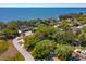 Aerial view of a lot outlined in green, showing surrounding homes, trees, and a lake in the background at 2930 Westgate Dr, Eustis, FL 32726