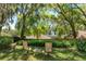 Lawn chairs sit beneath mature, mossy trees, overlooking manicured landscaping in this backyard at 2930 Westgate Dr, Eustis, FL 32726