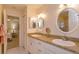 Well-lit bathroom featuring granite countertops, dual sinks, white cabinetry, and a tile floor at 2930 Westgate Dr, Eustis, FL 32726