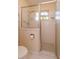 Bathroom shower stall featuring glass doors, honeycomb tiles, and a neutral color palette at 2930 Westgate Dr, Eustis, FL 32726