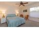 Relaxing bedroom featuring a ceiling fan, cozy seating, and a soft blue bedspread at 2930 Westgate Dr, Eustis, FL 32726