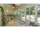 Bright sunroom with tile floors, ceiling fan, and views of the lush backyard and patio at 2930 Westgate Dr, Eustis, FL 32726