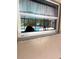 An outside view of a pool visible through a window with a granite sill and white frame at 100 Huntswood Ct, Longwood, FL 32750