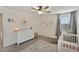 Charming Bedroom featuring a white dresser, crib, and stylish decor for a cozy and inviting space at 10509 Authors Way, Orlando, FL 32832