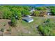 Scenic aerial view of a house surrounded by lush green trees and vegetation in a sunny, green area at 10544 Parkway Dr, Clermont, FL 34711