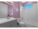 A delightful bathroom with purple walls featuring a tub-shower combination and a gray vanity sink at 10544 Parkway Dr, Clermont, FL 34711