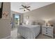 Cozy bedroom features a ceiling fan, white furniture, and a window overlooking the outdoor landscape at 10544 Parkway Dr, Clermont, FL 34711