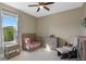 Charming Bedroom features a wood crib, a dresser, a comfy chair and an exterior view through a window at 10544 Parkway Dr, Clermont, FL 34711