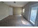 Spacious bedroom featuring carpet flooring, a window, and a side door for back access at 1060 Walt Williams Rd, Lakeland, FL 33809