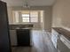 Kitchen with updated gray wood flooring, chandelier, and plenty of natural light from bay windows at 1060 Walt Williams Rd, Lakeland, FL 33809