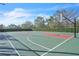 Outdoor basketball court with green and red painted keys and chainlink fence surrounded by trees at 11754 Barletta Dr, Orlando, FL 32827