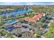 Aerial view of clubhouse featuring pools, tennis courts, basketball court, and community amenities with water views at 11754 Barletta Dr, Orlando, FL 32827