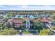 Luxury clubhouse featuring a clock tower, lakeside views, lush landscaping, and upscale amenities at 11754 Barletta Dr, Orlando, FL 32827