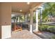 Inviting front porch with brick flooring, decorative pillars, seating, and views of the landscaped surroundings at 11754 Barletta Dr, Orlando, FL 32827