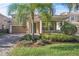 Charming two-story home featuring a brick driveway, lush landscaping, and a welcoming covered front porch at 11754 Barletta Dr, Orlando, FL 32827