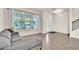 Cozy living room featuring tiled floors, a comfortable gray sofa, and large windows with natural light at 11754 Barletta Dr, Orlando, FL 32827