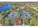 Aerial view of community tennis courts with lush landscaping, shade trees, water views, and parking at 11754 Barletta Dr, Orlando, FL 32827