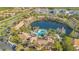 Beautiful aerial view of the pool, lake, and amenity center surrounded by palm trees in a well maintained community at 1290 Grady Ln # 20232, Davenport, FL 33896