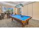 Game room with blue felt billiard table, custom light fixture and barstool seating at a high top table at 1290 Grady Ln # 20232, Davenport, FL 33896