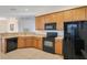 Functional kitchen featuring light wood cabinets and modern black appliances at 1290 Grady Ln # 20232, Davenport, FL 33896