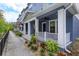 Inviting blue townhome with a covered porch, ceiling fan, and beautifully landscaped front yard at 1304 Spotted Sandpiper Loop, Winter Springs, FL 32708