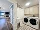 Functional laundry room with ample storage cabinets, sink, and modern washer and dryer at 1312 Golfside Dr, Winter Park, FL 32792