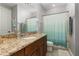 Bathroom featuring a vanity with a granite countertop, a large mirror, and a shower tub combo at 1403 Lake Whitney Dr, Windermere, FL 34786