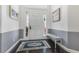 Bright foyer featuring gray accent walls, an accent rug, a sitting bench, and a front door at 1403 Lake Whitney Dr, Windermere, FL 34786