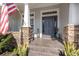 Inviting home entrance featuring stone accents, manicured planters, and a tiled front porch at 1403 Lake Whitney Dr, Windermere, FL 34786