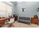 Bright home office space featuring a wooden desk, gray futon, and whimsical wall art at 1403 Lake Whitney Dr, Windermere, FL 34786