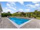 Backyard pool with a tiled waterfall feature, lounge chairs and mature landscaping at 1403 Lake Whitney Dr, Windermere, FL 34786