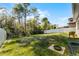 Large grassy backyard with some mature trees and a sturdy black wrought iron fence at 14090 Alafaya Oak Bnd, Orlando, FL 32828