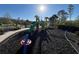 Well-maintained playground featuring a slide and various play structures, set against a sunny sky at 14090 Alafaya Oak Bnd, Orlando, FL 32828