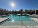 Bright and sunny community pool surrounded by palm trees and lounge chairs, perfect for relaxation at 14090 Alafaya Oak Bnd, Orlando, FL 32828