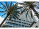 Exterior shot of a modern high-rise building with private balconies and palm trees at 150 E Robinson St # 405, Orlando, FL 32801