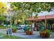 Inviting view of restaurant with outdoor seating, surrounded by lush greenery and flowering trees at 150 E Robinson St # 405, Orlando, FL 32801