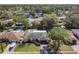 Aerial view of a home with a pool and well-manicured landscaping surrounded by mature trees and other homes at 1617 E Sandpiper Trl, Casselberry, FL 32707