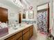 Bathroom features a vanity with drawers, a sink, mirrors and a shower stall visible through the doorway at 1617 E Sandpiper Trl, Casselberry, FL 32707